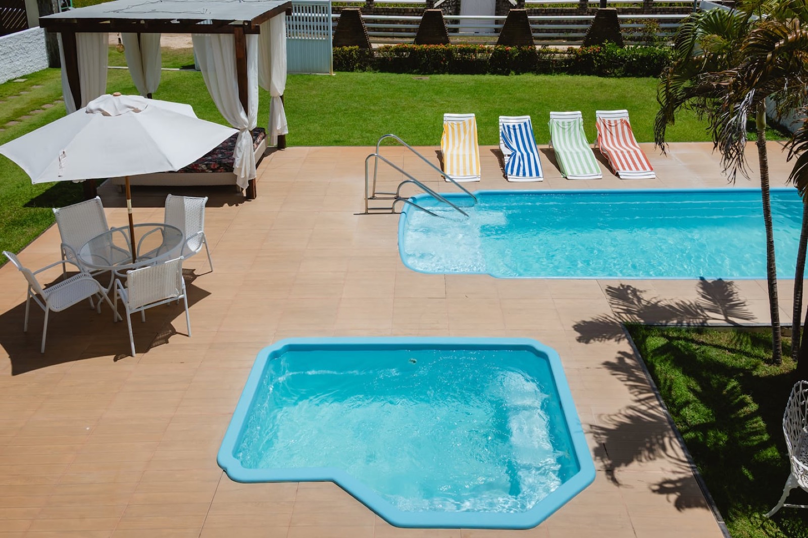 Piscina, jacuzzi e área de lazer de casa administrada na Praia do Saco